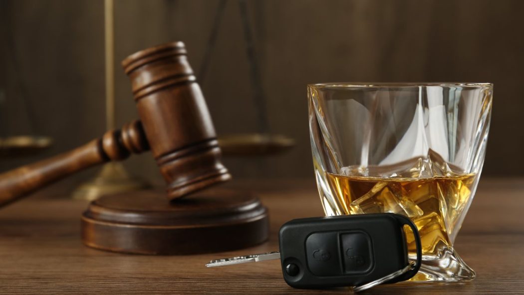 DUI Lawyer concept featuring a judge’s gavel, a glass of whiskey, and car keys, highlighting the importance of a skilled DUI Lawyer for legal defense after a drunk driving charge.